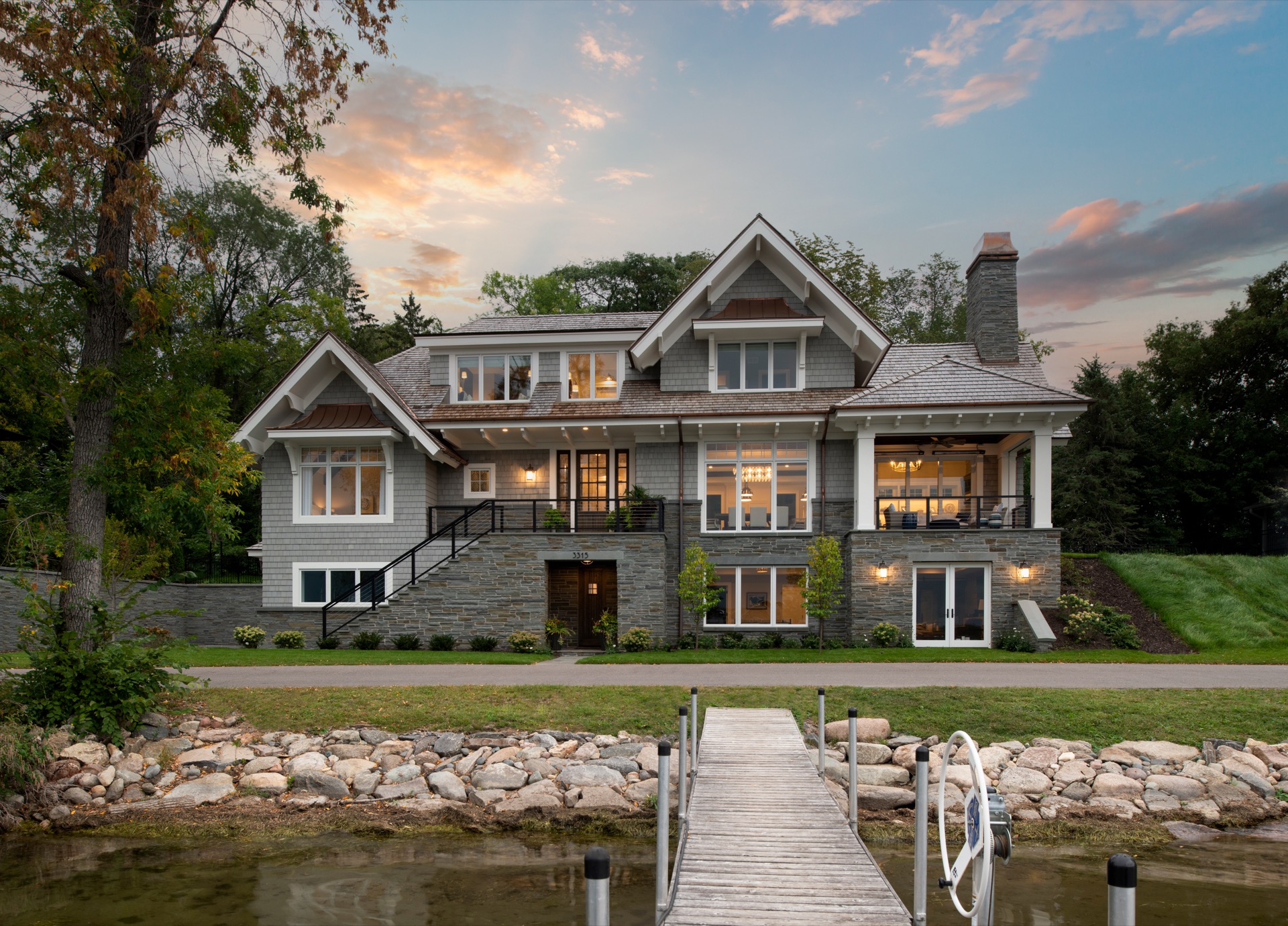 The view from a dock of a Gordon James luxury lakeside home on Crystal Bay in Minnetonka, Minnesota at dusk.