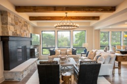 Modern chalet-inspired living room with stone hearth Gordon James luxury lakeside mansion in Wayzata, Minnesota
