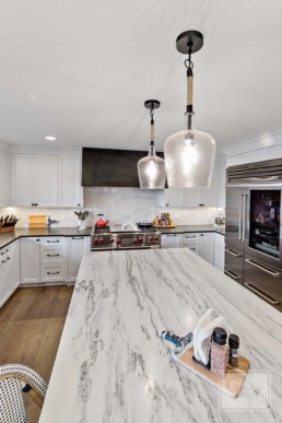 Picturesque country styled kitchen of a Gordon James' luxury home in Wayzata, Minnesota features top quality marble countertops