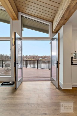 Open floor to ceiling doors offer a glimpse of the gorgeous Shaver's Lake in a custom-built Gordon James residence in Wayzata, Minnesota