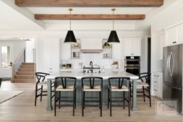 A farmhouse inspired kitchen in a custom Haus of Rowe Interiors designed Gordon James luxury home in Minnetrista, Minnesota blends luxury and functionality.
