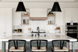A farmhouse inspired kitchen in a custom Haus of Rowe Interiors designed Gordon James luxury home in Minnetrista, Minnesota blends luxury and functionality.