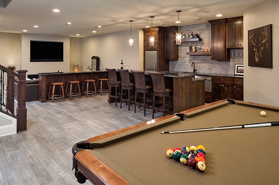 A living room in a Gordon James custom luxury home features a pool table and bar for the ultimate home theatre experience.